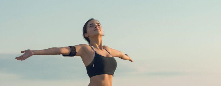 Woman standing outdoors with her arms outstretched