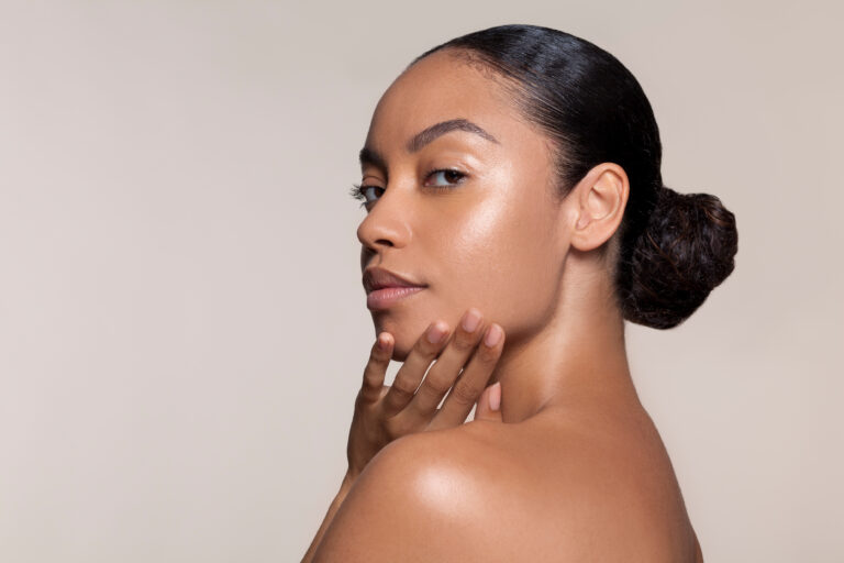 Woman looking over her shoulder with her hand at her chin