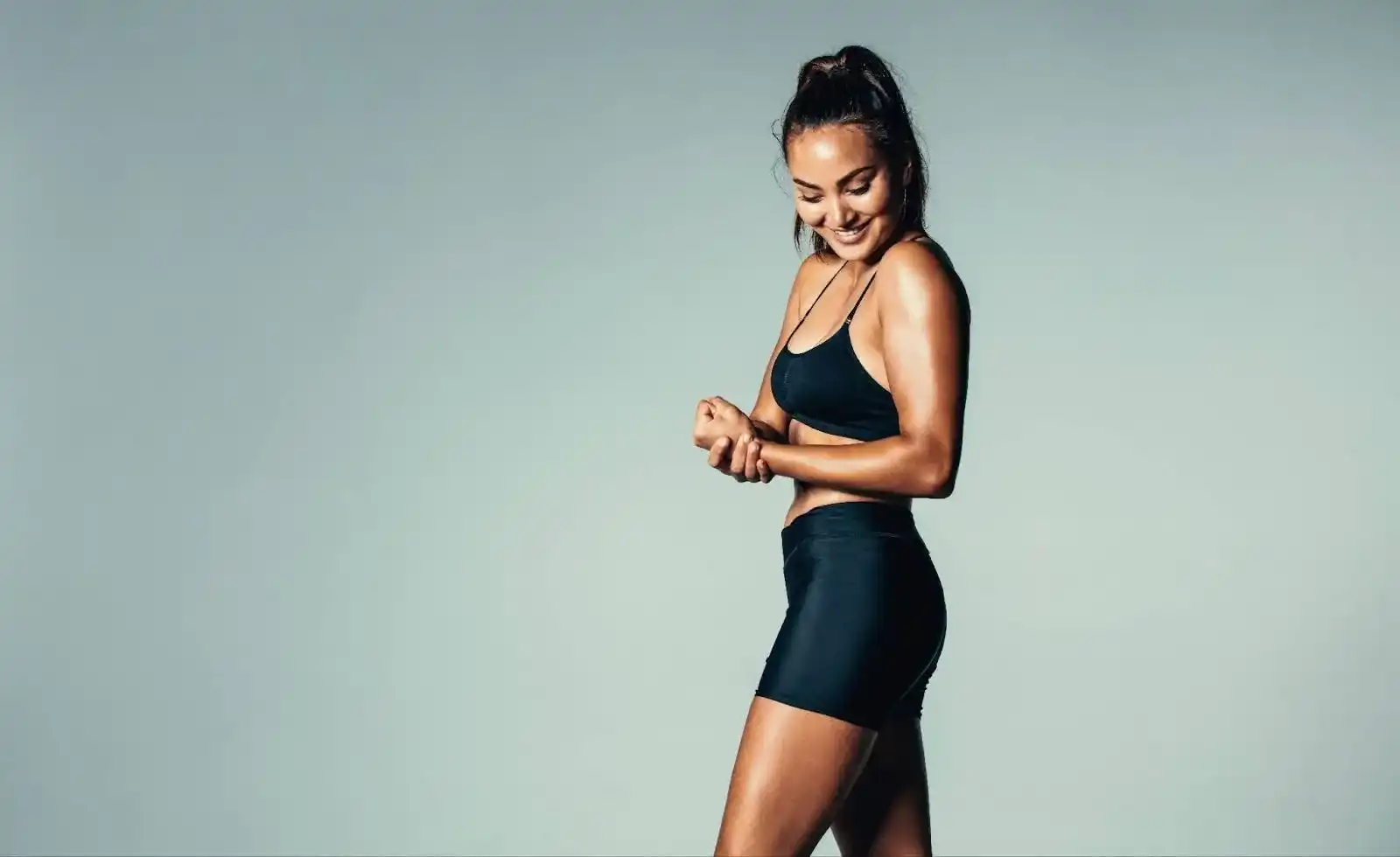 Athletic woman holding her leg to represent muscle pain