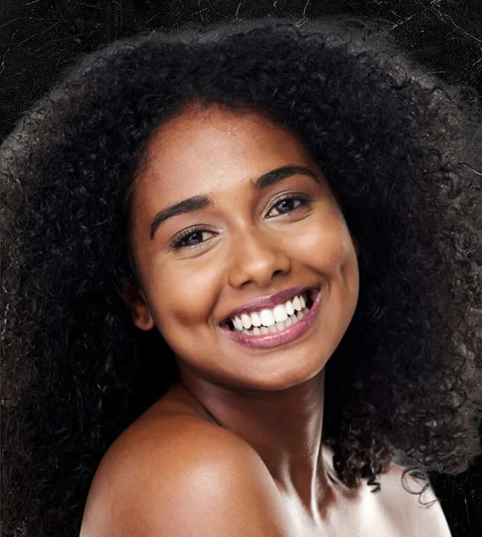 Smiling woman with natural curly hair looking over her shoulder