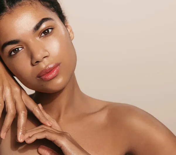 Woman with radiant skin posing with her hand near her face